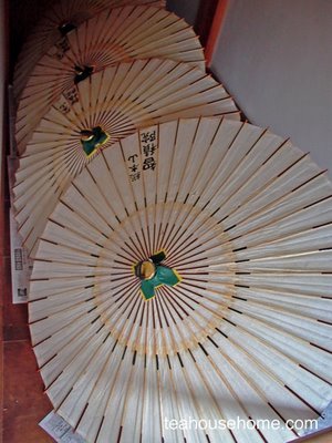 photograph of freshly made parasols drying in a temple hallway, Kyoto, Japan by A.E. Graves